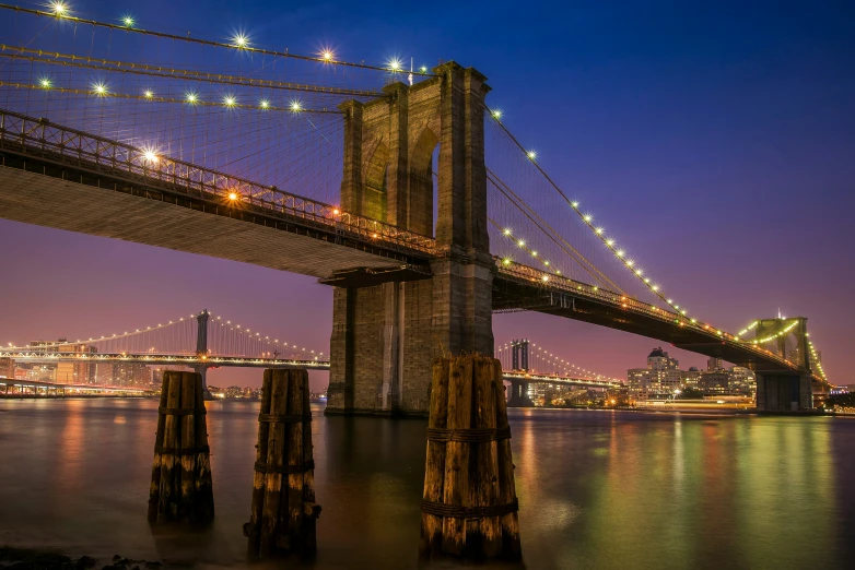 some buildings water lights and the brooklyn bridge