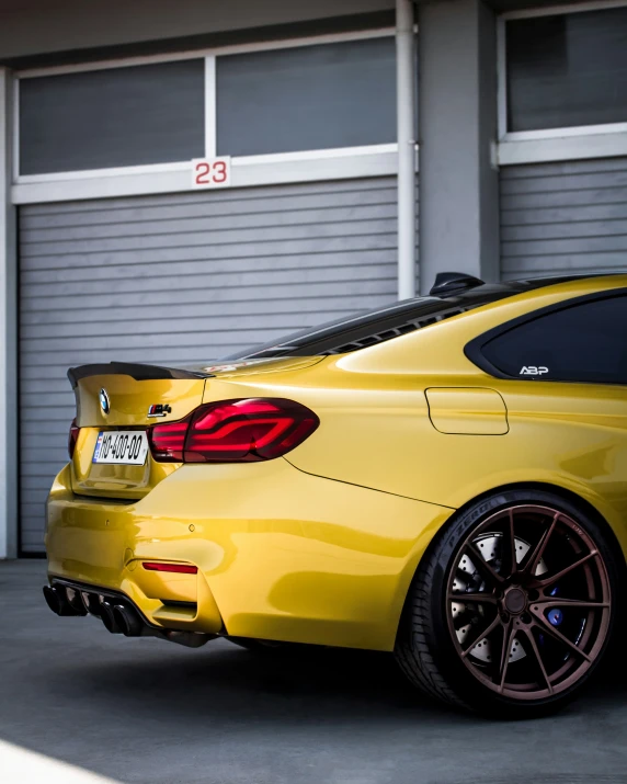 a yellow sports car is parked in front of a garage