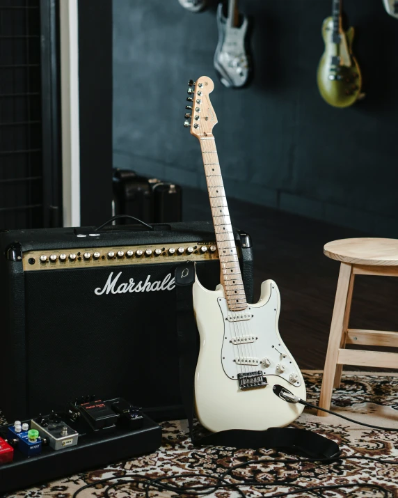 two guitars and a amp sit on a rug