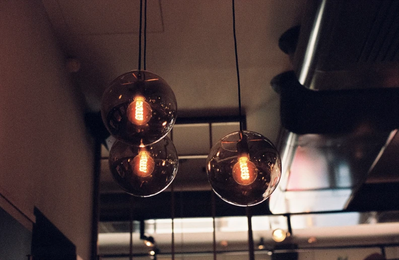 three chandeliers hanging down from the ceiling in a restaurant