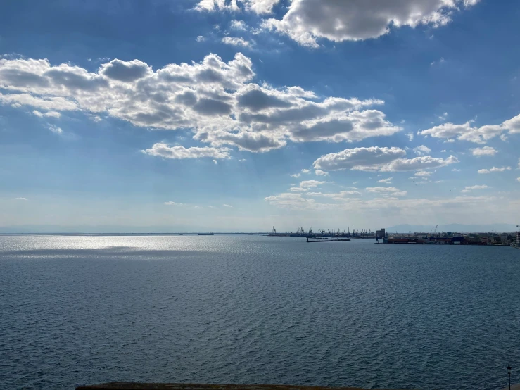 a lake sitting below a cloudy blue sky