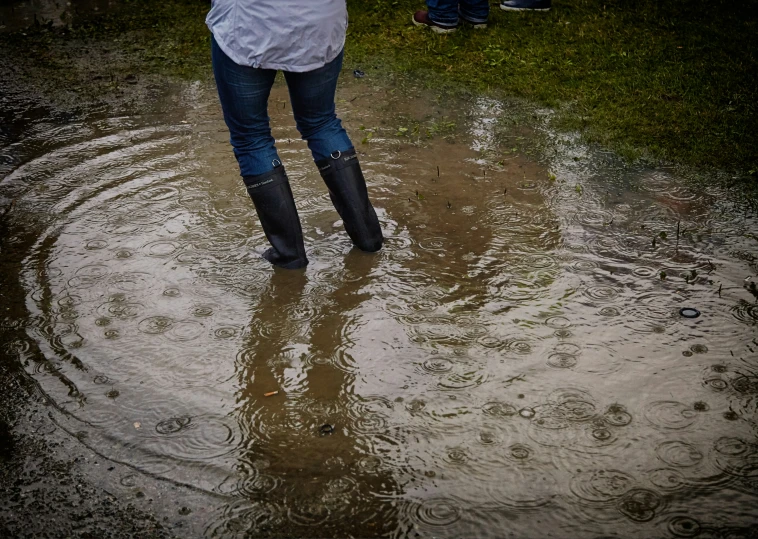 a woman is standing in the water holding her umbrella