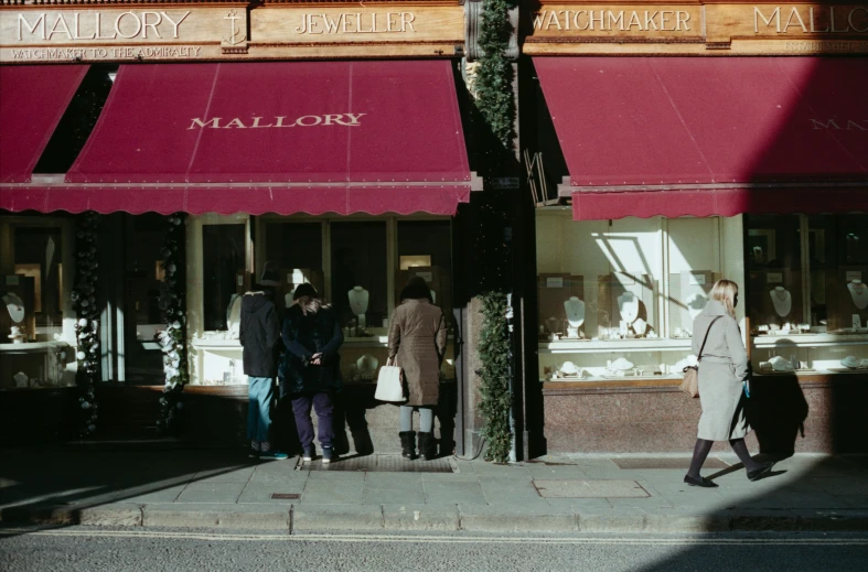 people are waiting in line on the sidewalk