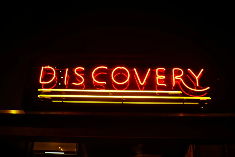 neon sign that says discovery on it in dark