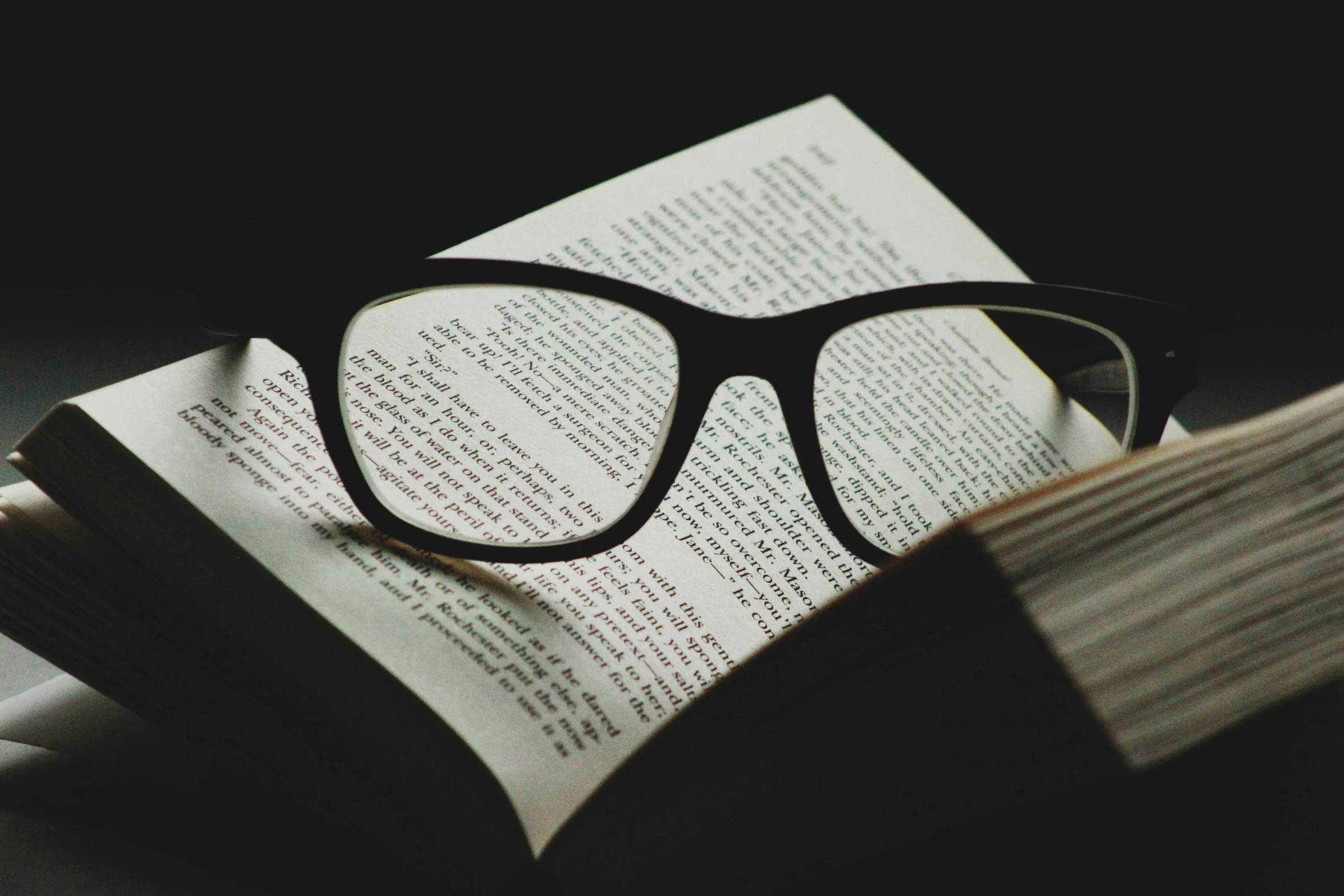 there is an open book and some reading glasses