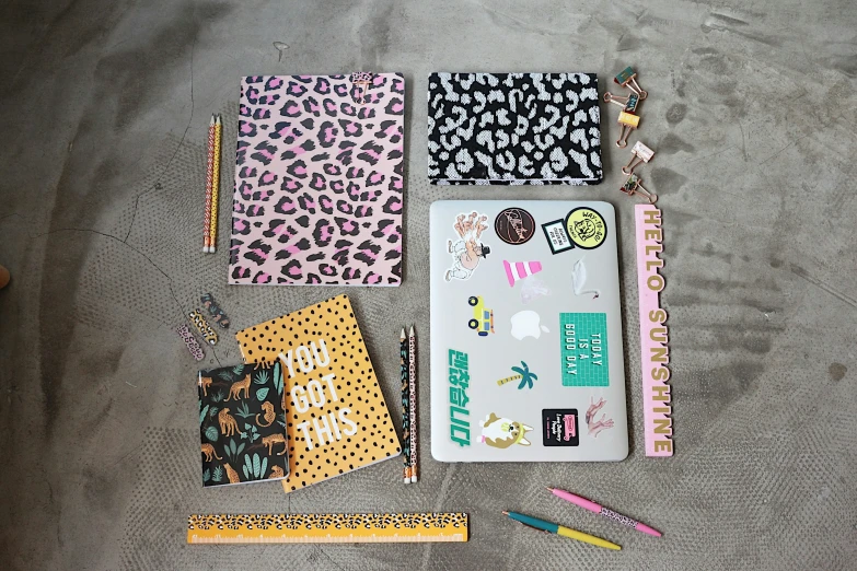 a variety of craft items including notebooks, pens and a marker board