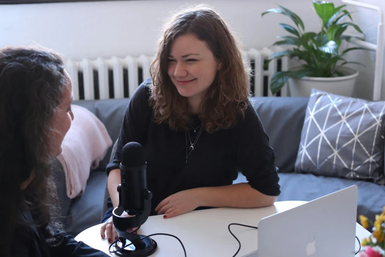 the woman is holding the object and talking to the other person