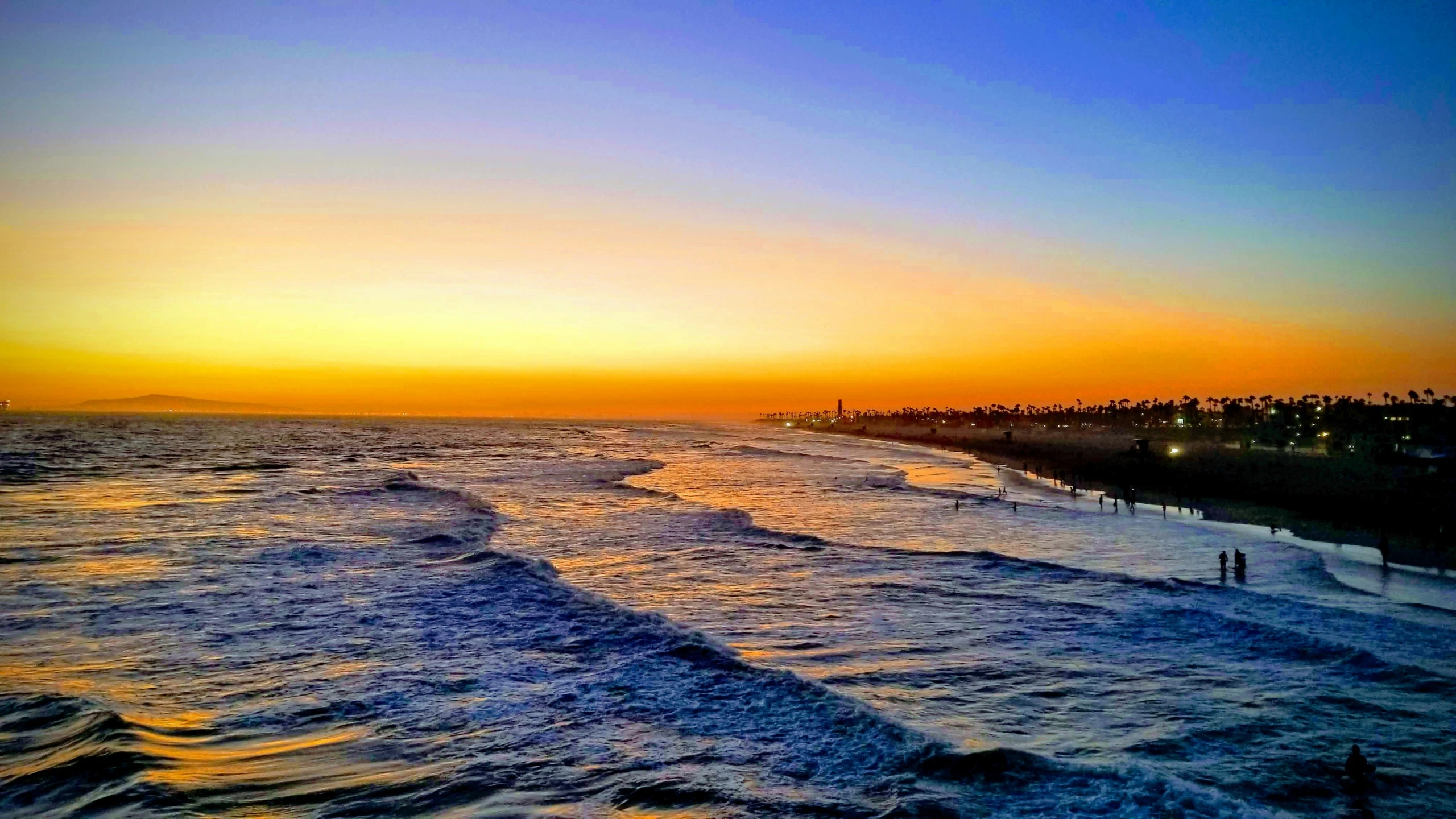 the sun is setting over the ocean at the beach