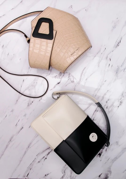 a couple of purses laying on top of a white table