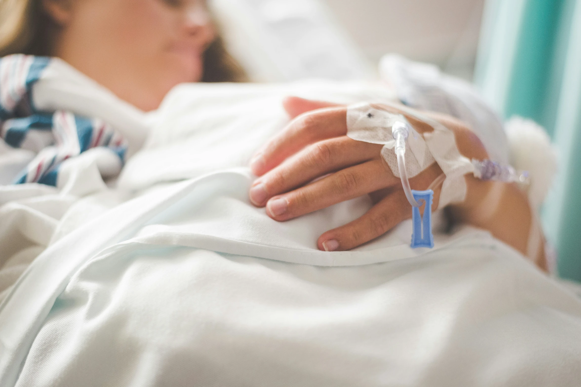 a female in a hospital bed with her hand wrapped up