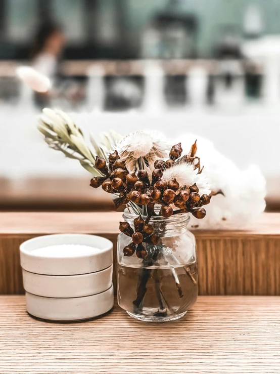 some cotton and some dried flowers in a jar