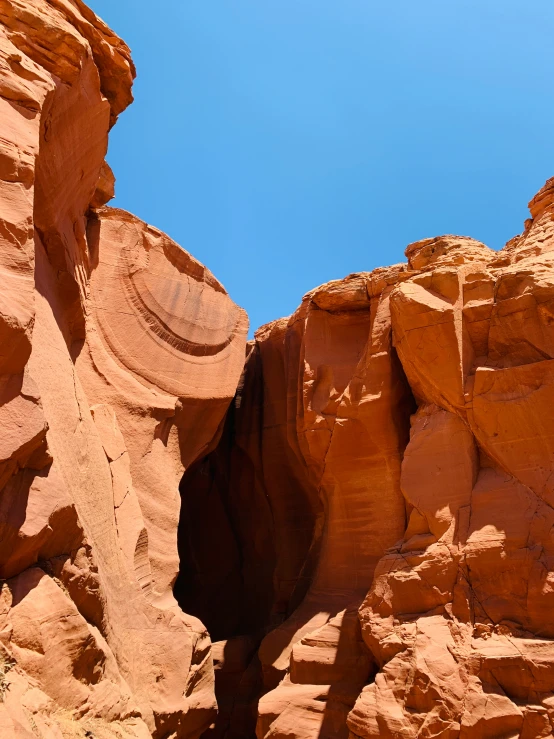 a tall brown rock formation near another rocky mountain