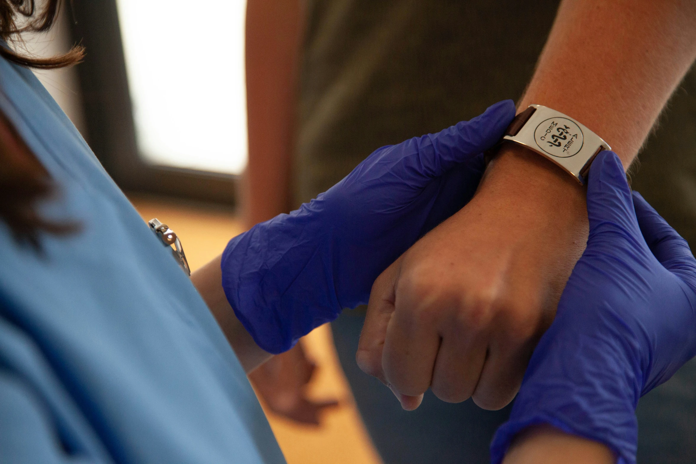 two people in blue gloves are holding each other's hand