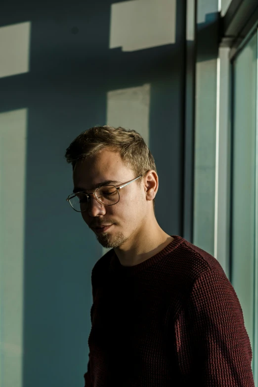 man standing in front of building next to window and sunlight