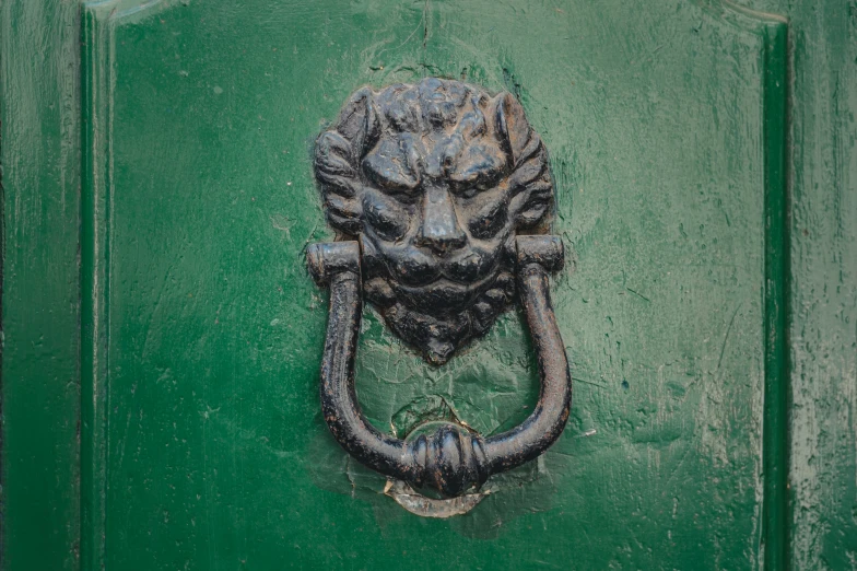 a metal handle is attached to a green door