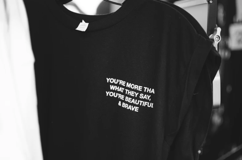 a black shirt with words written in white on the side of the shirt