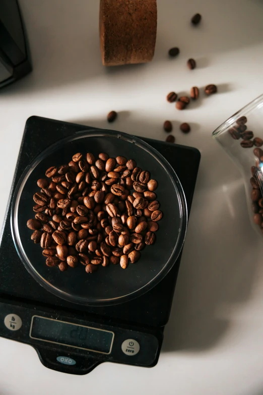 there is a small bowl full of coffee beans on the scale