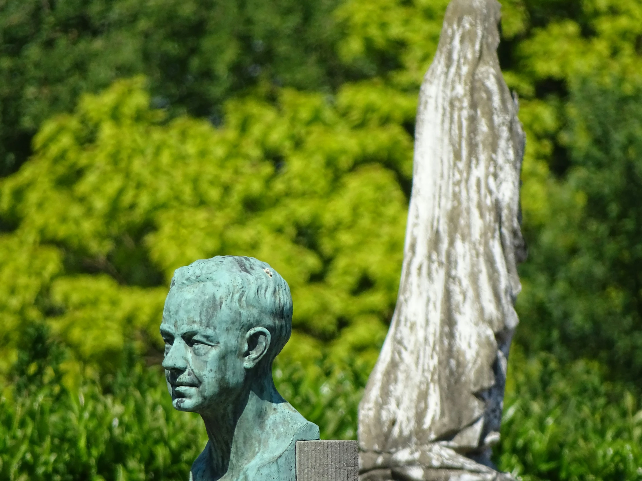 a green statue in front of a tree