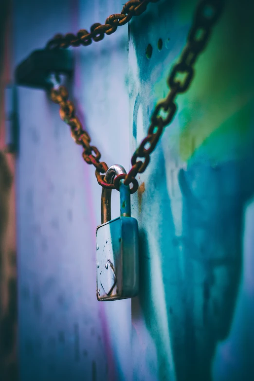 a combination lock hangs from a wall with a chain