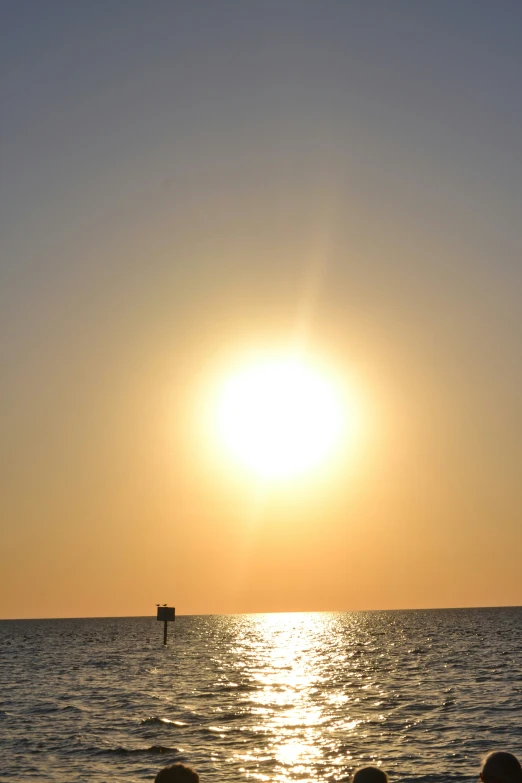 a boat traveling past a sun that is setting