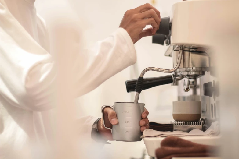 someone making soing from a coffee pot next to some espressos