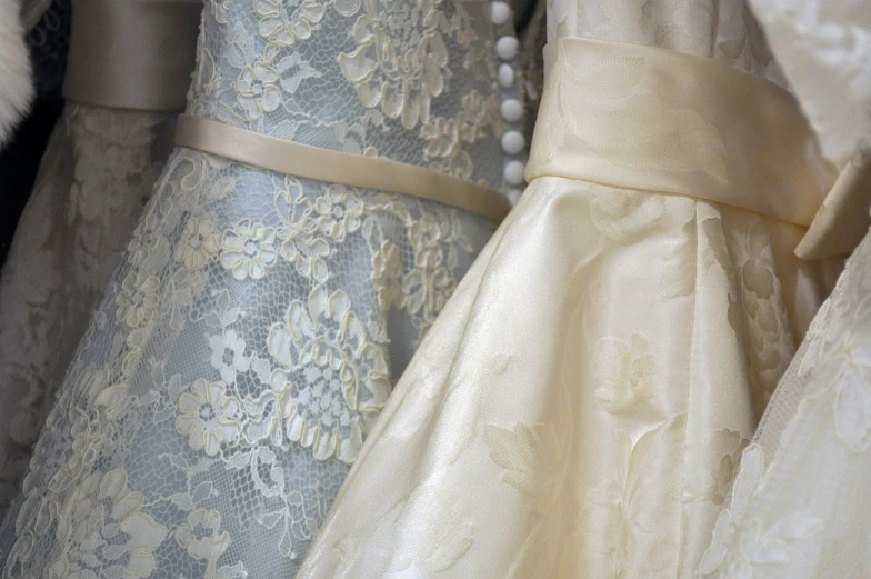 two dresses with pearls lined up on display