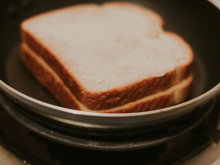 a slice of bread that is cooking in a frying pan