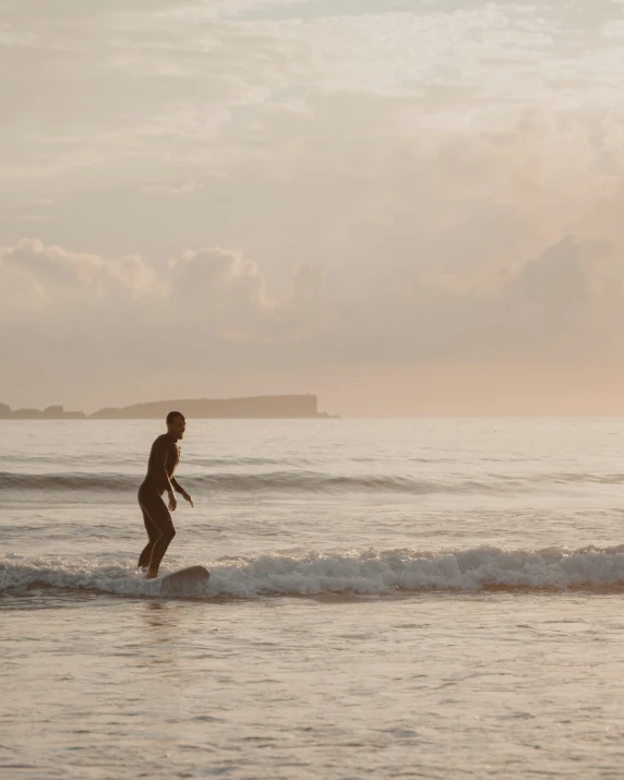 a person that is standing in the water with a surfboard