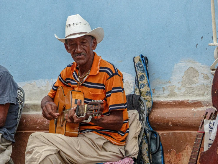 an older man sitting next to an adult with musical instruments