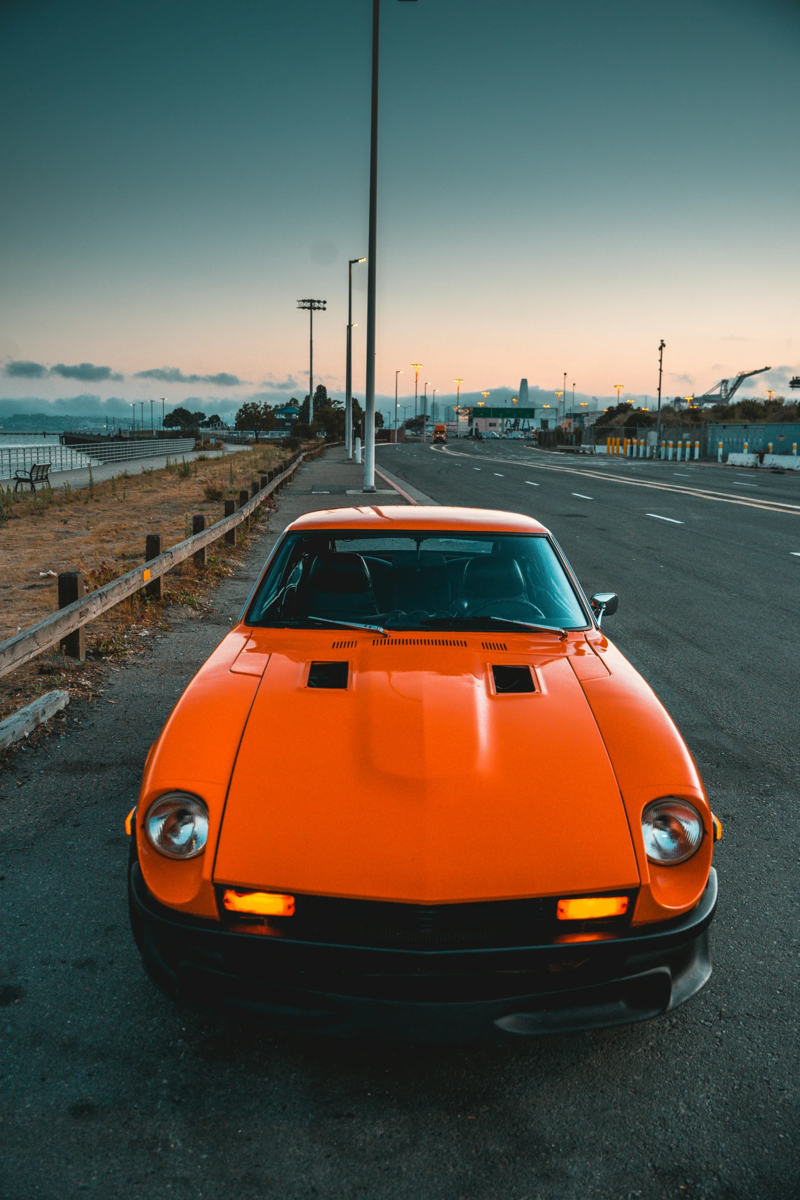 orange sports car on street next to a road