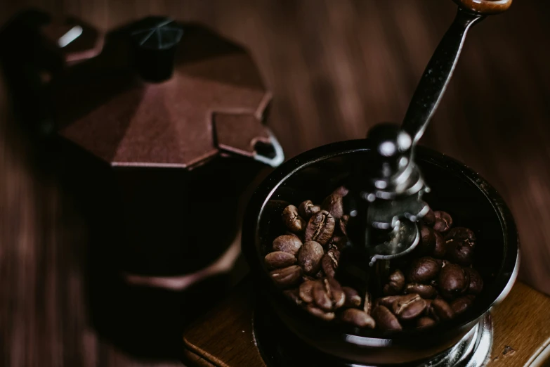 coffee beans being stirred into a cup in a small container