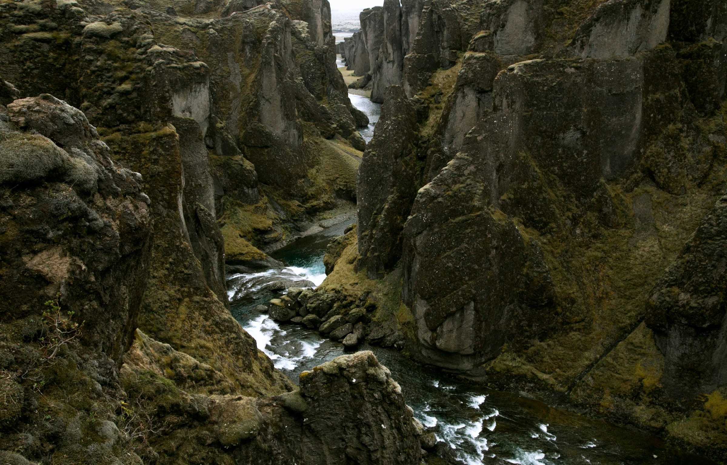 a river flowing through a canyon surrounded by tall rocks