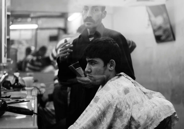 a man sitting in a barber chair getting his hair cut