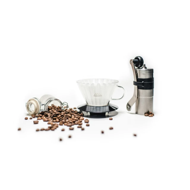 a small grinder, coffee maker, and other items on a table