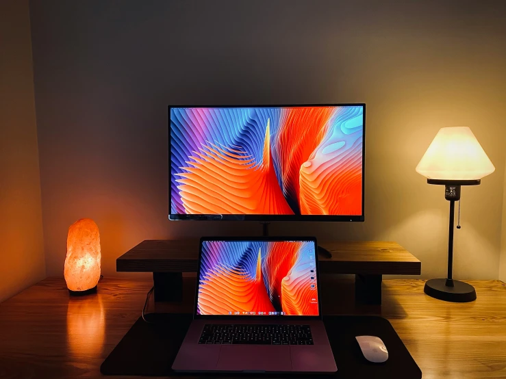 a desk with a laptop and a monitor on it