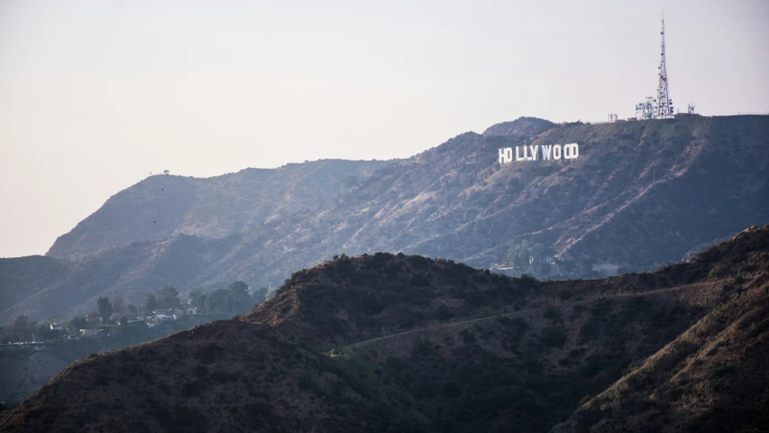 the hollywood sign sits on top of a hill