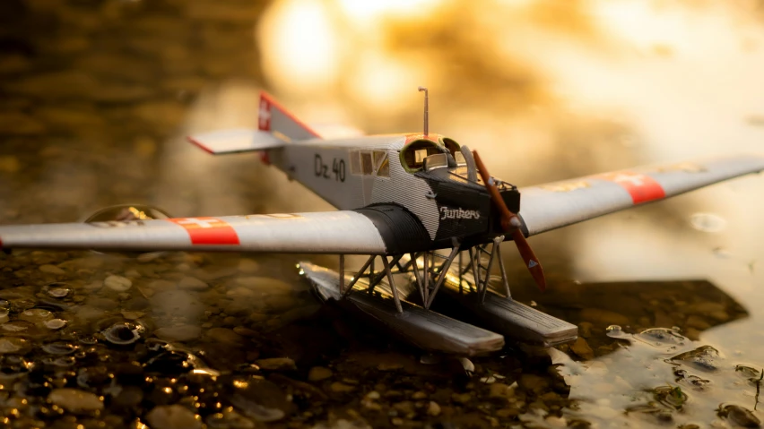 small model aircraft on a muddy surface with some mud around it