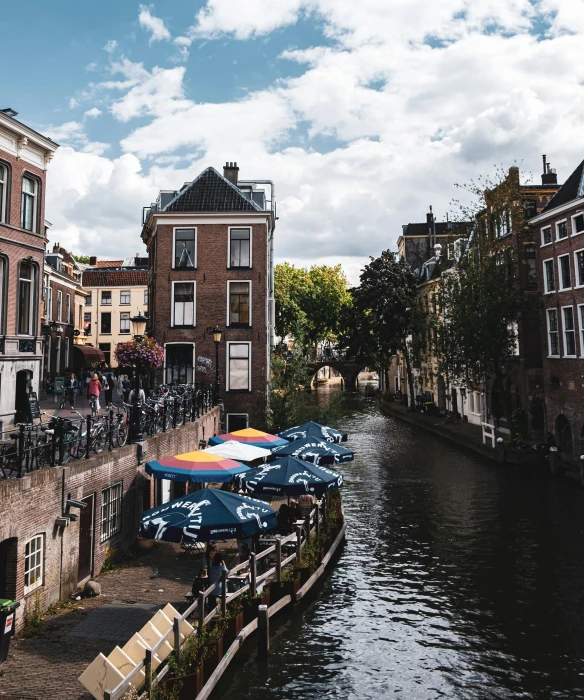 some people and bicycles on a bridge over a canal