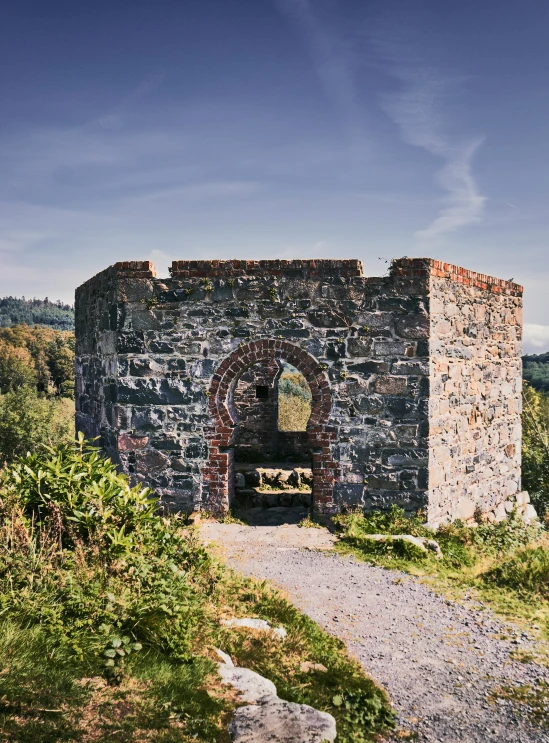 a stone gate sitting on the side of a hill