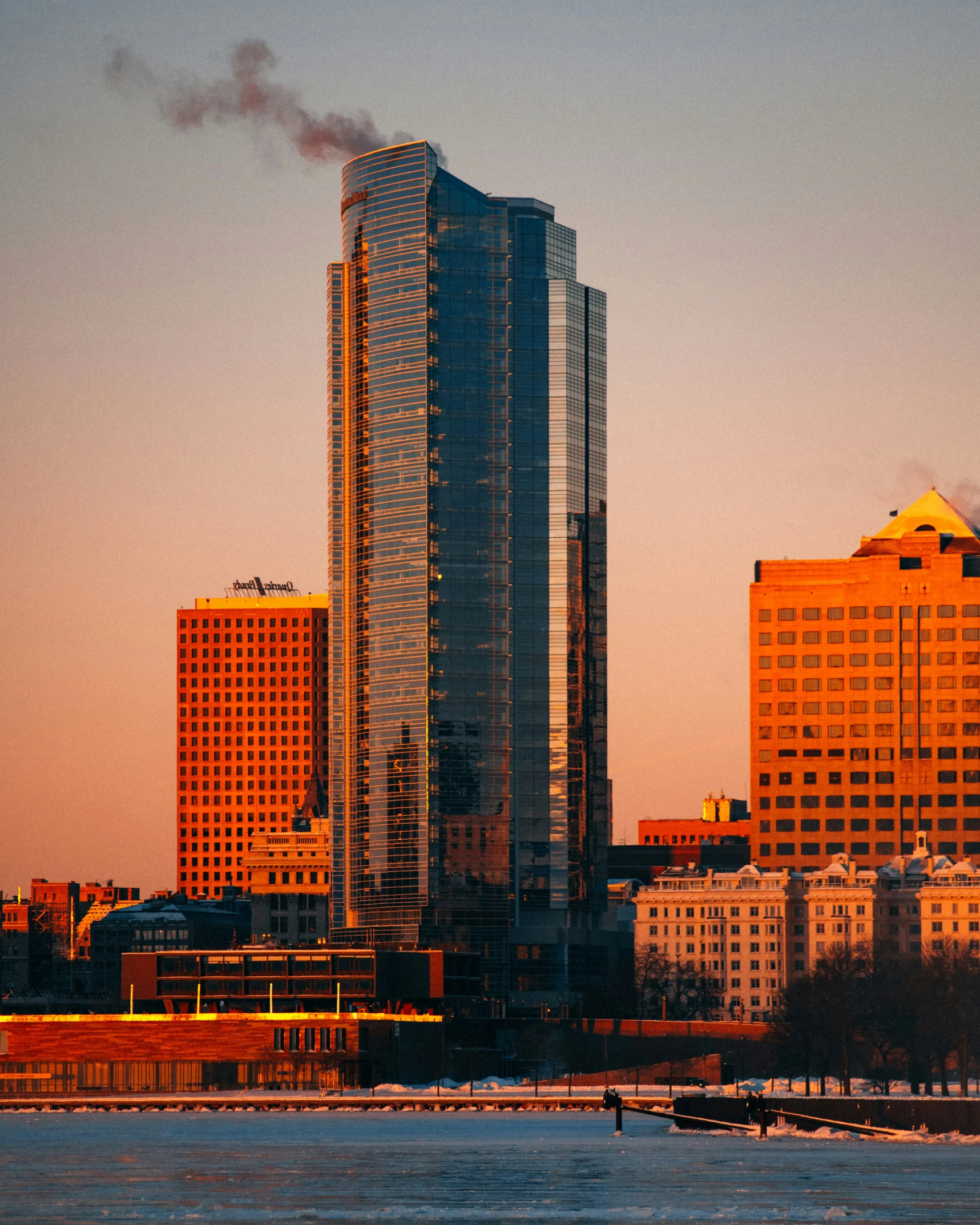 a city skyline is shown with skyscrs rising above the water