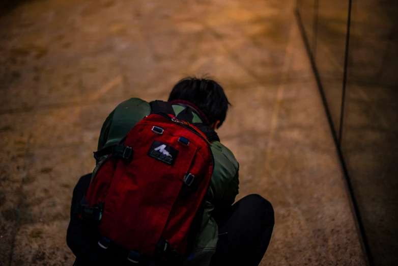 a backpacker looking down at soing on the ground