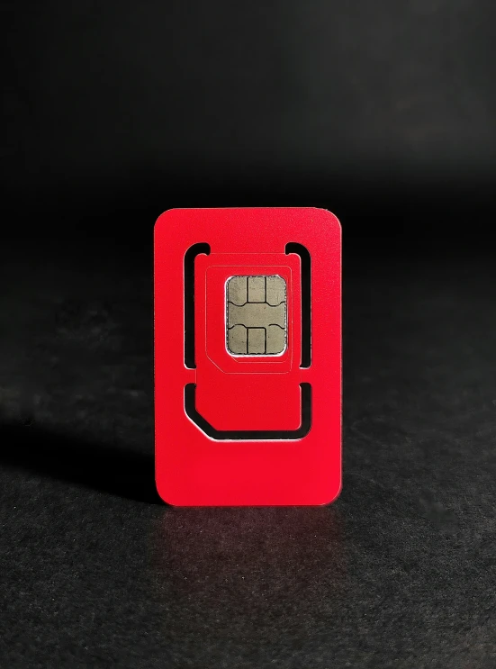 a square red cellphone sitting on top of a table