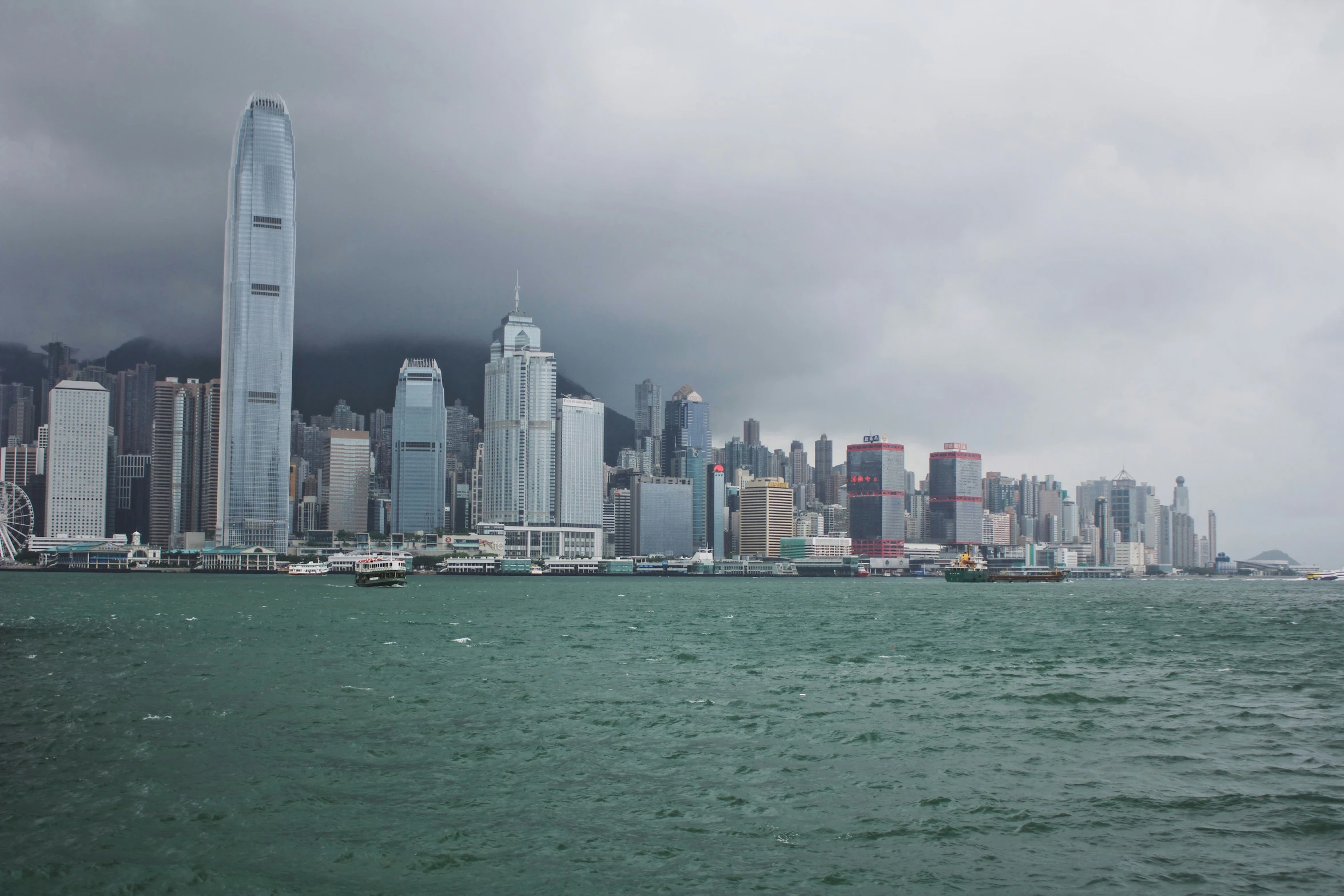 a very large city in the distance under some grey clouds