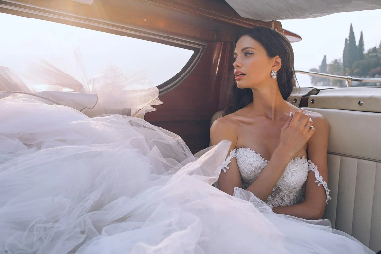 a young beautiful woman sitting inside of a wedding car