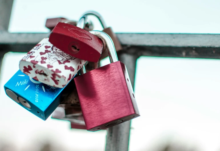 the lock on the iron gate is decorated with four padlocks