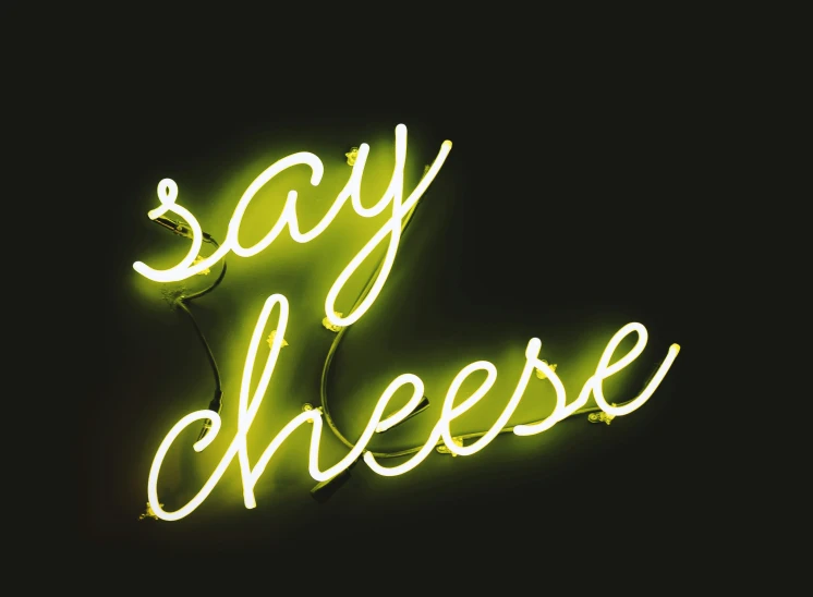 neon sign that says say cheese in the dark