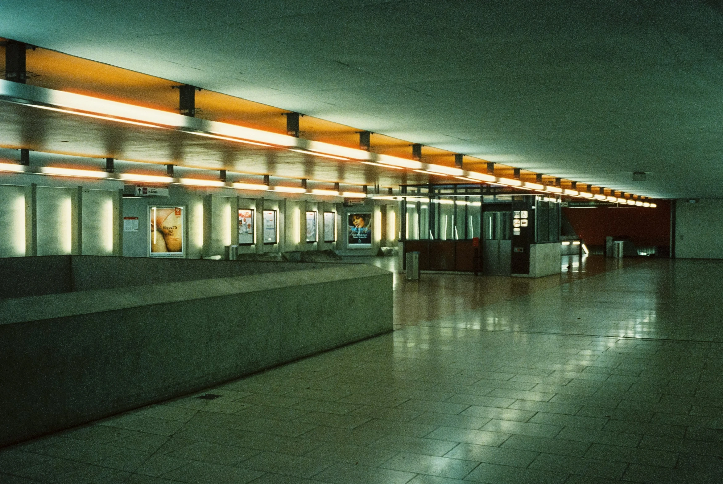 a man and woman walk through an empty hallway in a building