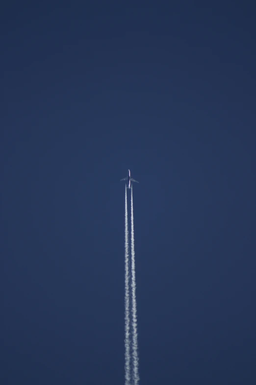 an aeroplane with trails leaving behind in the air