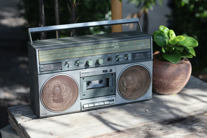 an old radio sits next to a potted plant
