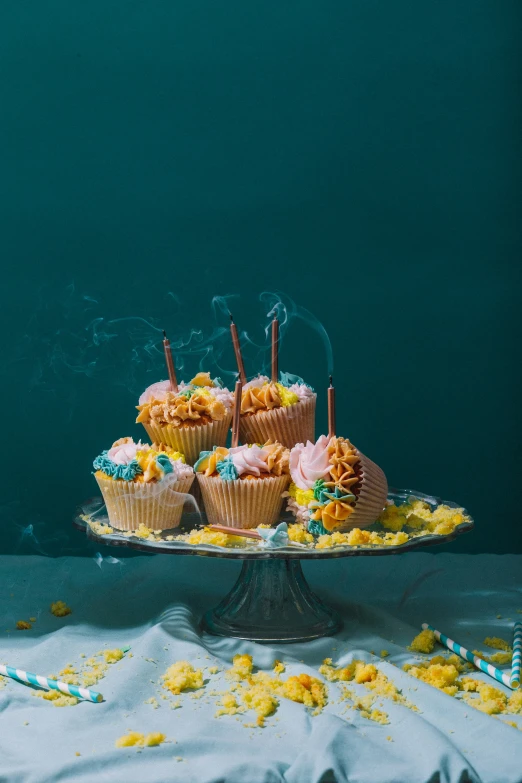 an assortment of cupcakes on a metal cake stand